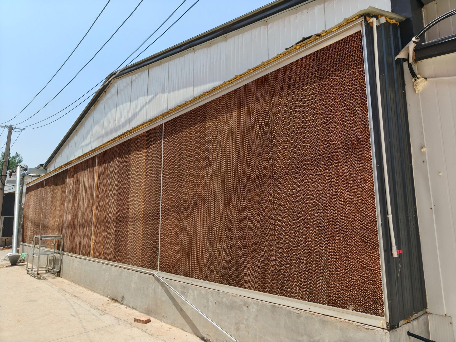 Cooling pad water curtain system for closed poultry house ventilation